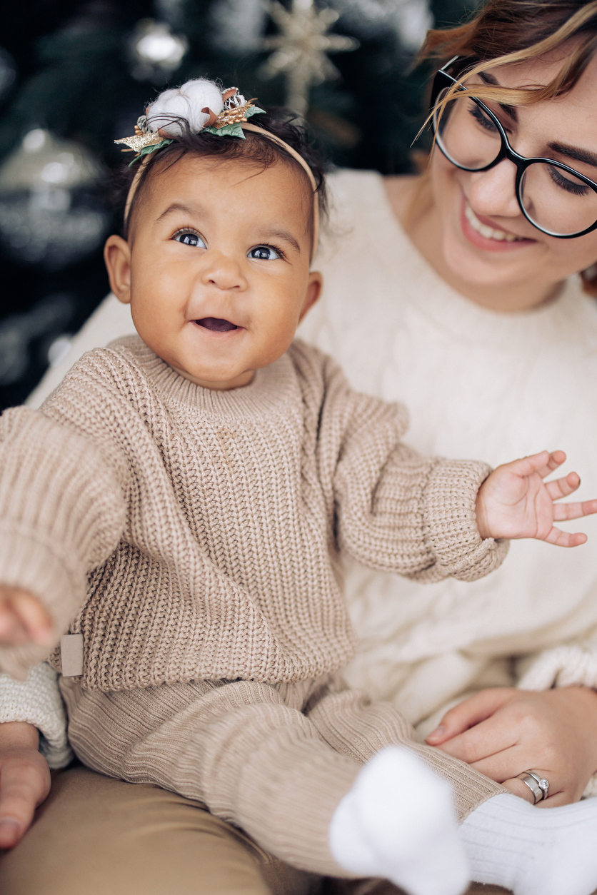 Portrait of mother and her baby daughter sitting and smiling together