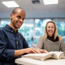 Visually impaired man reading braille.