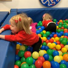 Young girl playing in a ball pit.