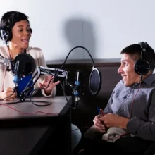 Woman and young man with disabilities recording a podcast.
