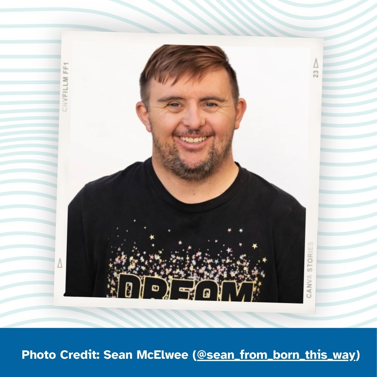 A man with Down syndrome smiles at the camera. He wears a black t-shirt that reads "DREAM" with colorful stars. Photo Credit: Sean McElwee (@sean_from_born_this_way)